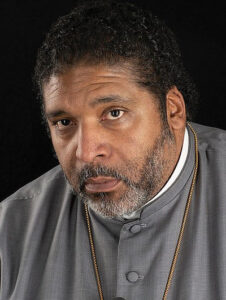 The Rev. Dr. William J. Barber wearing a gray cassock.