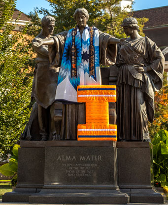 Alma Mater Statue at the University of Illinois Urbana-Champaign blanketed in a blue star quilt for Native American Heritage Month.